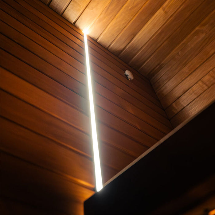 Interior ceiling view of the Jonas Grand 8-person sauna showing vertical ambient light strip along the corner wall and wooden panelling.