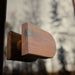 Close-up of the exterior wooden door handle on the Jonas Grand 8-person outdoor sauna, mounted on a reflective glass door.