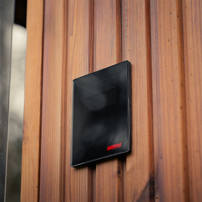Harvia digital control panel mounted on the exterior timber wall of the Jonas Grand 8-person outdoor sauna.
