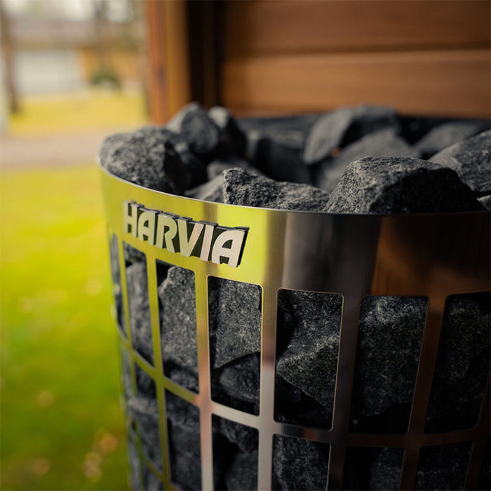 Close-up of the Harvia sauna heater label and volcanic stones used in the Jonas Grand 8-person sauna for authentic steam bathing.