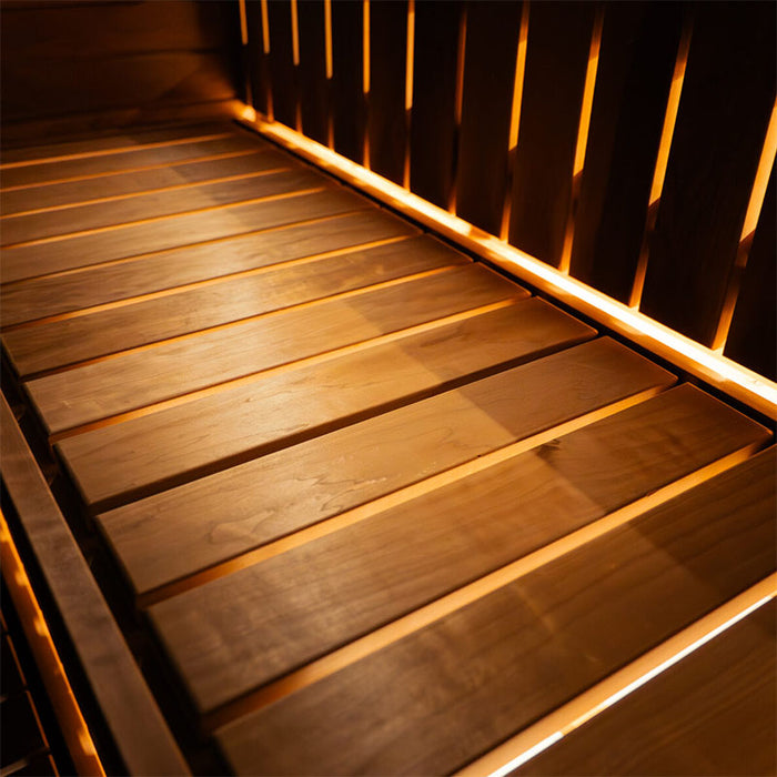Upper wooden bench inside the Jonas Grand 8-person sauna illuminated by soft indirect lighting, showcasing ergonomic seating design.