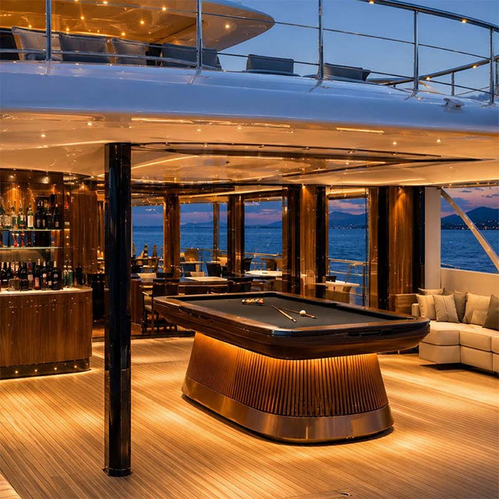 Koralturk Atlantis Gyroscopic Pool Table illuminated within a luxury superyacht entertainment lounge overlooking the sea.