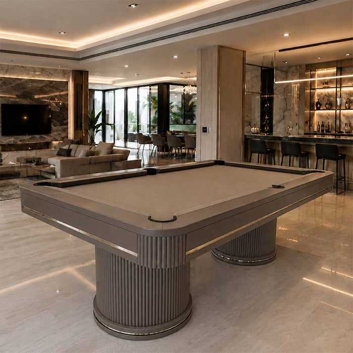 Koralturk Elit luxury pool table in a grey finish with matching cloth, fluted pedestal legs and metallic accents in a contemporary interior.