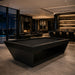Black Koralturk Kaplankaya Pool Table with matching dark cloth and sculptural angular base in a sophisticated luxury interior at night.