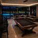 Koralturk Legnora luxury pool table with black cloth and elegant wooden frame in a sophisticated poolside living room.