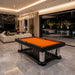 Koralturk Luxury Cage Pool Table with orange cloth, chrome columns and distinctive cage-style base in a luxury living room.