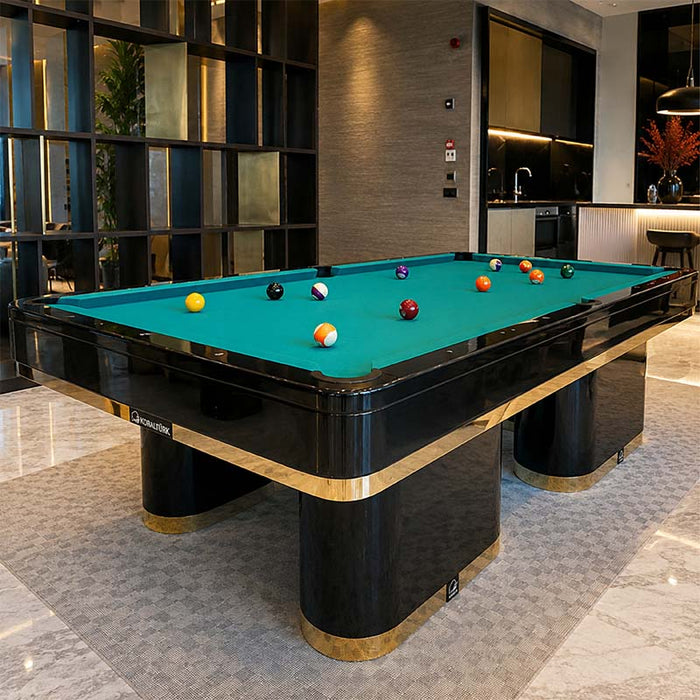 Koralturk Trapeza Pool Table with green cloth, glossy black frame, gold detailing and billiard balls in a luxury interior.
