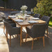 Larissa Outdoor Dining Set in a garden setting, featuring a 6-seater table and rattan chairs.