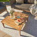 Larissa Outdoor coffee table with drinks and flowers.