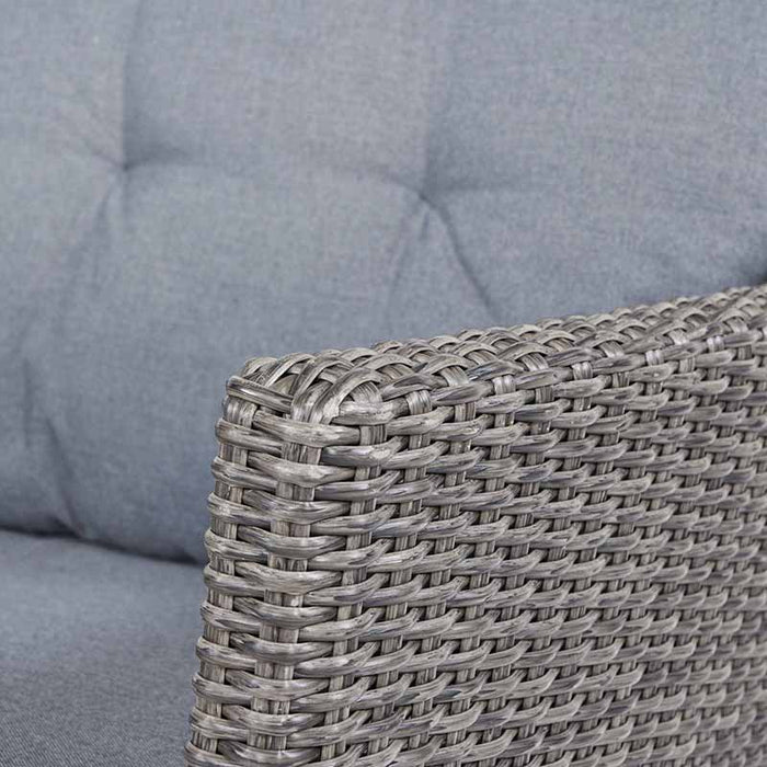 A detailed shot of the Larissa Outdoor Seating Set armrest, focusing on the rattan weave and the plush grey cushion.