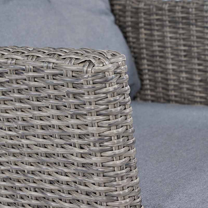 A close-up of the armrest, showcasing the intricate rattan weave and sturdy acacia wood frame.