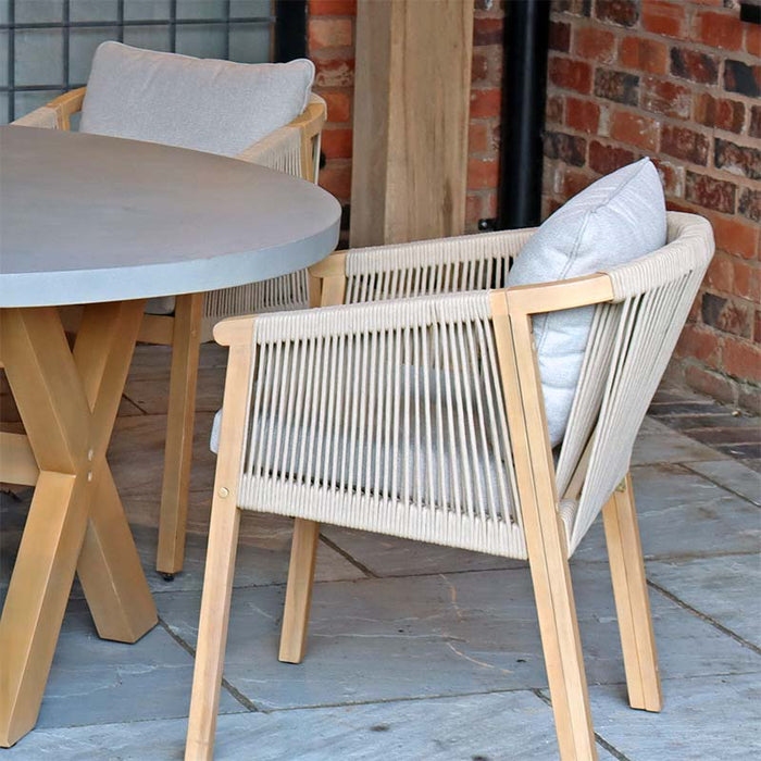 A side perspective highlighting the comfort and design of the chair, paired with the sleek round concrete table from the Luna 6 Seater Concrete Table Dining Set.