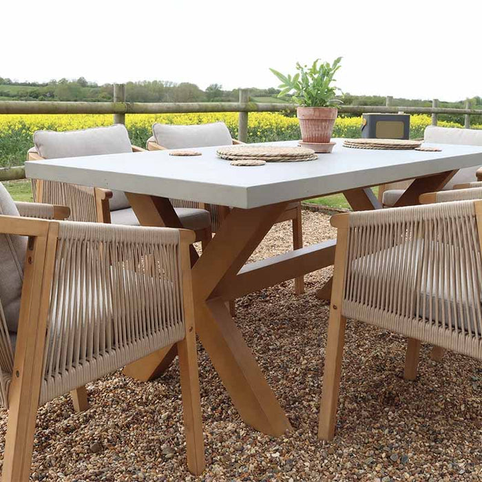 A close-up view of the rope chairs and concrete table, displaying the beautiful contrast between natural wood, concrete, and woven rope.