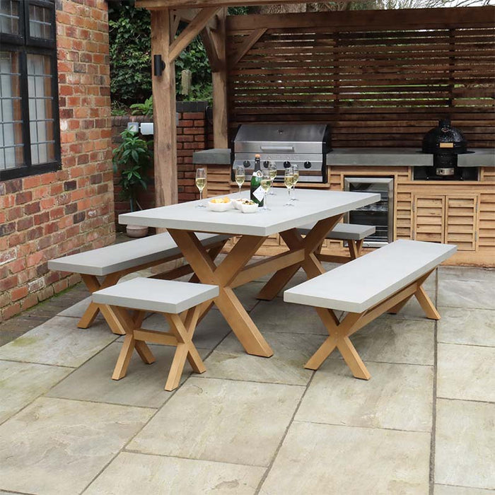 Luna 8 Seater Rectangular Concrete Dining Table with wooden benches arranged in a stylish outdoor setting.