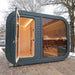 Exterior side view of Viking Industrier Luna Outdoor Sauna with open glass door.