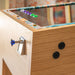 Rear angled view of Maison Roshi Jiraiya Pinball Machine with turquoise and orange patterned side artwork and natural wood frame in dining room.
