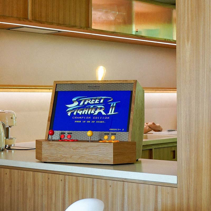Maison Roshi Sensei V1 arcade cabinet on a modern kitchen counter, running Street Fighter II with vintage-style red and yellow controls on a wooden console.