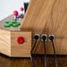 Close-up of the rear panel of the Maison Roshi Sensei V3 arcade machine showing robust power and USB ports with a polished oak wood finish.
