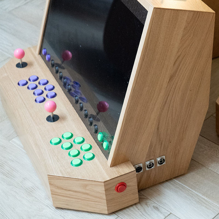 Close-up angled shot of Maison Roshi Sensei V3 arcade system, showing LED-lit buttons, pink joysticks, and detailed wood craftsmanship.