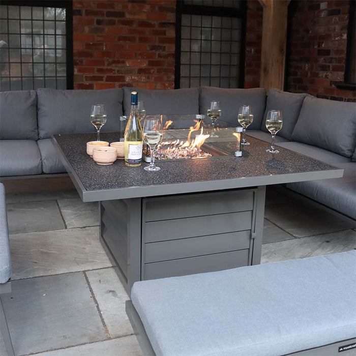 A close-up of the fire pit table from the Mayfair Corner Lounge Set, with drinks and snacks displayed, capturing the warm and inviting atmosphere ideal for evening gatherings.