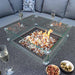 A top-down perspective of the Mayfair Corner Lounge Set's fire pit table, featuring sparkling fire glass and elegant glass wind guards, enhancing the sophisticated outdoor dining experience.