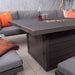 A close-up of the Mayfair Fire Pit Table with its sleek, tempered glass top, complemented by the comfortable grey cushions and vibrant orange pillows on the lounge set.