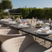 Ambition 10 seater extending dining set in oatmeal, close-up view of the table setting with elegant tableware and champagne glasses.