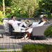 Two people relaxing on the Ambition 3 Seater Sofa Set in charcoal, enjoying a stylish outdoor seating experience with soft cushions and a modern coffee table.