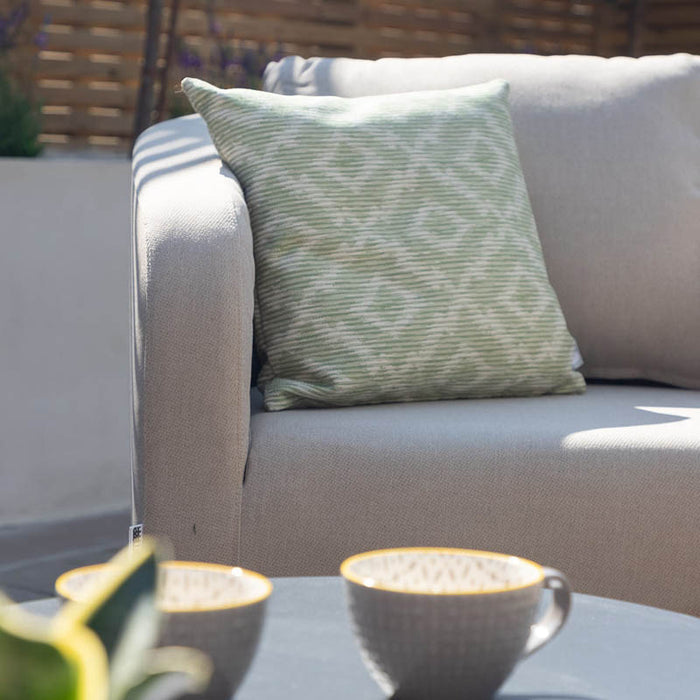 Close-up of the oatmeal sofa cushion with a green patterned pillow on the Ambition 3 Seater Sofa Set.