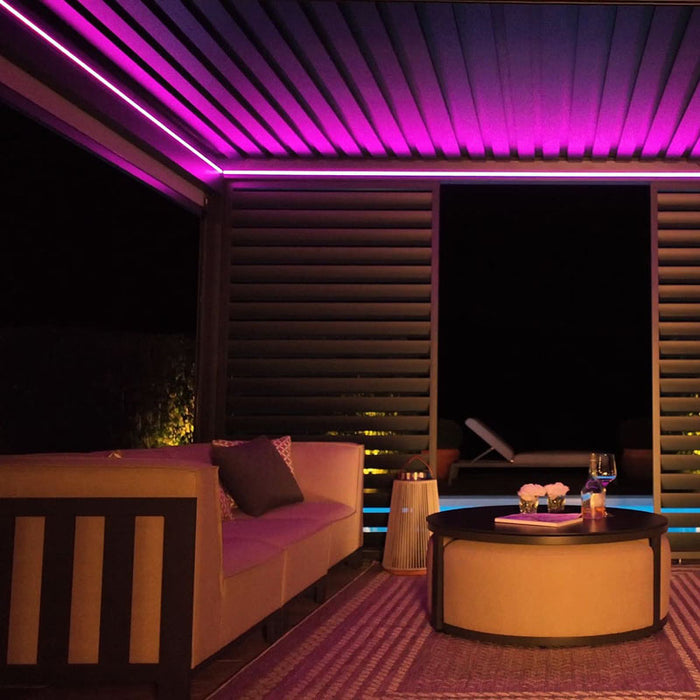 Eden Aluminium Garden Pergola illuminated with violet LED lights, creating a vibrant and relaxing outdoor environment for evening gatherings.