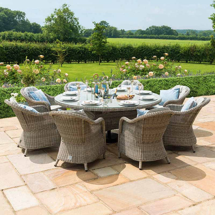 The Maze Oxford Heritage 8 Seater Round Dining Set elegantly placed in a garden setting, highlighting its suitability for luxurious outdoor dining.