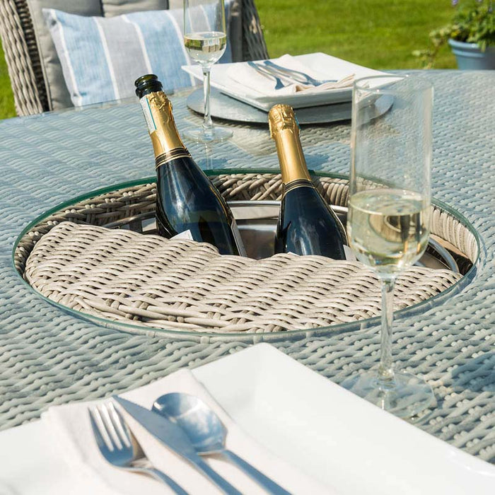 Close-up of the Maze Oxford Heritage dining table’s rattan lid, slightly ajar, revealing the integrated ice bucket, set against a detailed rattan weave.