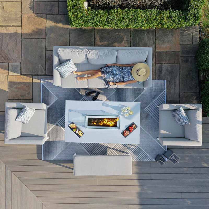 Daytime bird's-eye view of Pulse 3 Seater Sofa Dining Set with Fire Pit, woman relaxing on the sofa under the sun, lead chine cushions adding style.