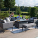 Outdoor family relaxing by the Pulse 3 Seater Sofa Dining Set with Fire Pit, surrounded by modern grey seating and lush garden views.