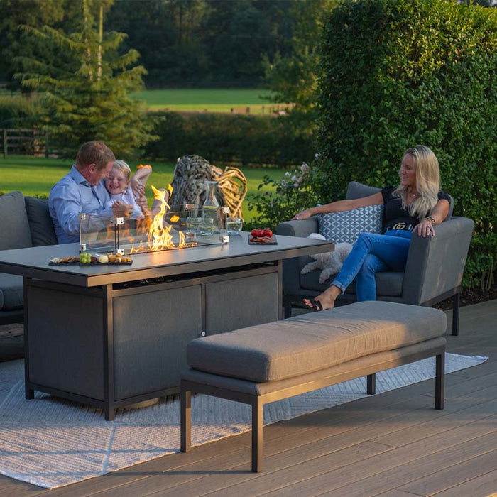 Family enjoying the Pulse 3 Seater Sofa Dining Set with Fire Pit outdoors.