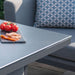 Close-up of tomatoes and cured meats on the Pulse Fire Pit table in flanelle grey.