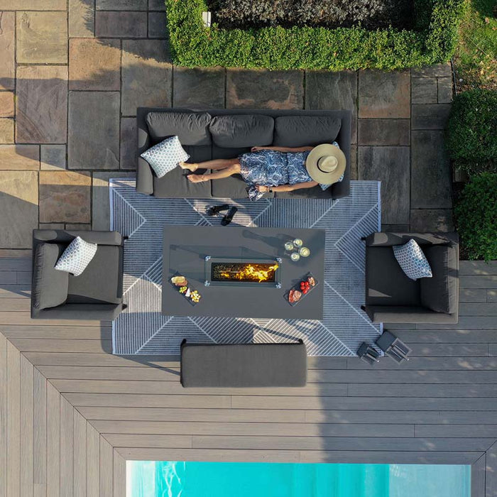 Bird’s eye view of a relaxed outdoor scene featuring the Pulse 3 Seater Sofa Dining Set with Fire Pit, with a person lounging in comfort.