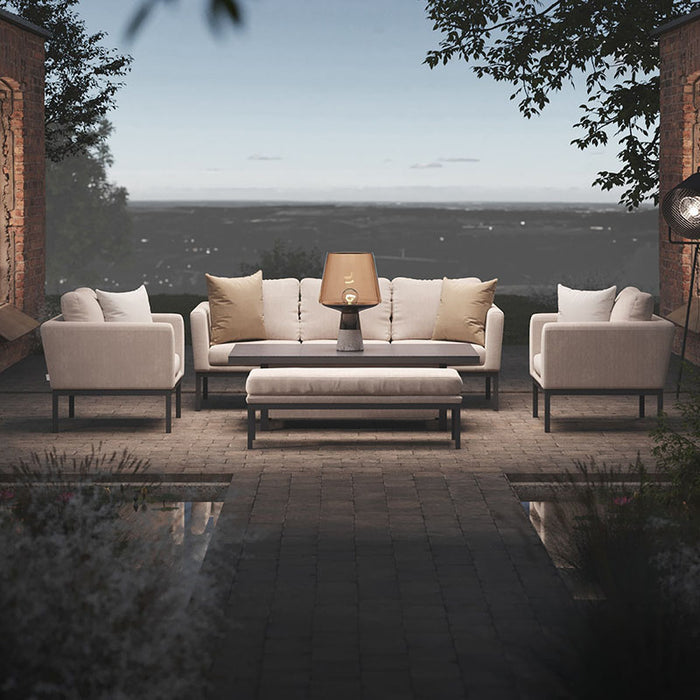 Elegant Pulse 3 Seater Sofa Dining Set in oatmeal with adjustable rising table in outdoor setting at dusk.