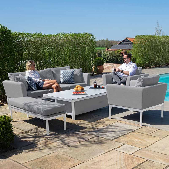 Two people seated on the Maze Pulse 3 Seater Sofa Dining Set, enjoying the comfortable grey seating and adjustable table functionality.