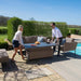 Another shot of the couple adjusting the height of the rising table in the Maze Pulse 3 Seater Sofa Dining Set in Taupe, illustrating the ease of use.