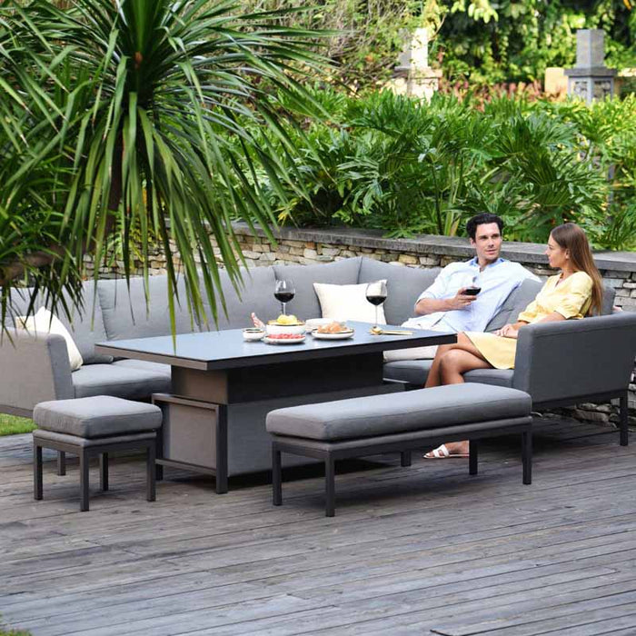 Relaxed outdoor dining scene featuring a couple seated at the Pulse Left-Handed Dining Set with its table raised, blending seamlessly with the natural garden backdrop.