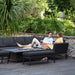 Relaxed couple enjoying an intimate moment on the Pulse Left Handed Rectangular Corner Dining Set with Rising Table, set in a serene garden, perfect for leisurely days.