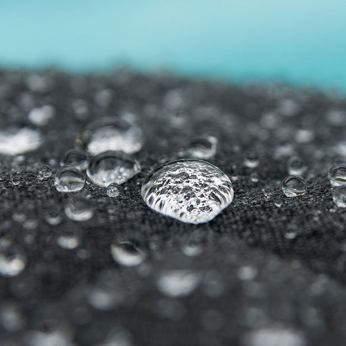 A detailed shot of water droplets on the Pulse Dining Set's charcoal fabric, demonstrating the set's water-resistant and quick-dry properties.