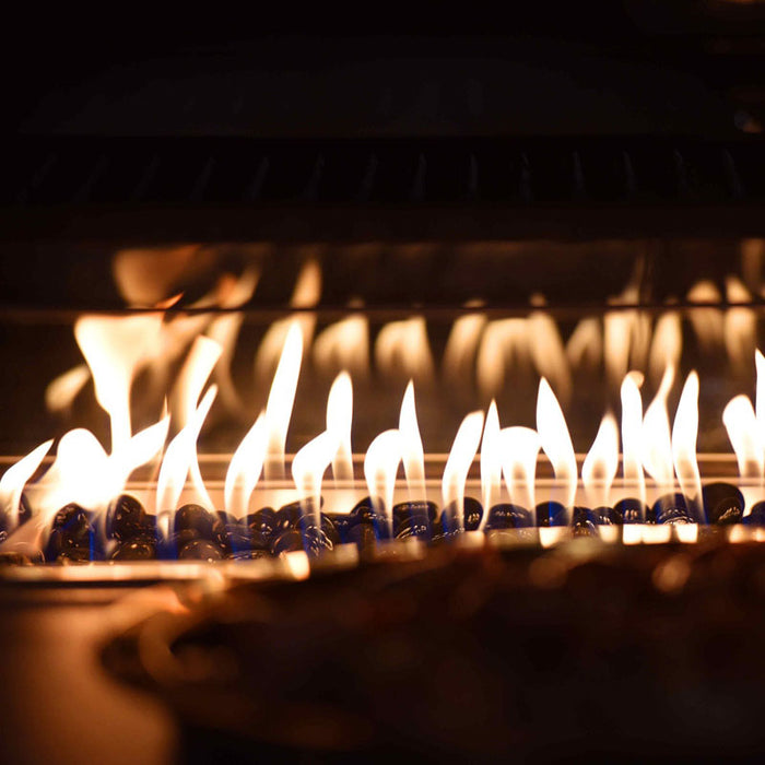 A close-up of the flickering flames in the fire pit, providing warmth and ambience for the Pulse Square Corner Dining Set with Fire Pit in charcoal.