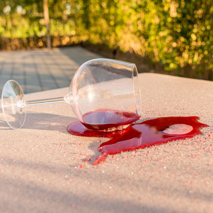 A close-up image of spilled red wine on the stain-resistant fabric of the Pulse Square Corner Dining Set in taupe, showcasing the easy-clean feature and durability for outdoor use.