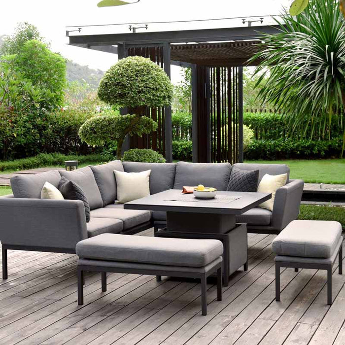 Pulse Square Corner Dining Set with Rising Table in flanelle, displayed in a patio outdoor setting with trees and cushions.