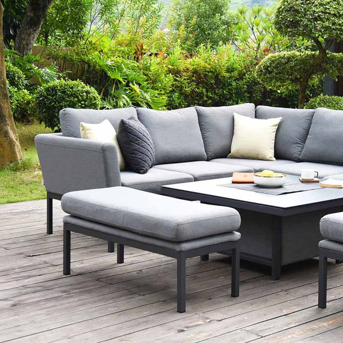 Pulse Square Corner Dining Set with Rising Table in a garden setting. The grey cushioned corner sofa and benches offer a modern outdoor seating arrangement, complemented by an adjustable square table for versatile dining and lounging.