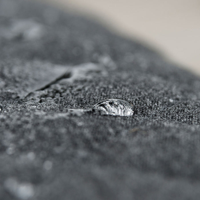 Close-up of water drops on the charcoal fabric of the Pulse Square Corner Dining Set, showcasing water-resistant material.