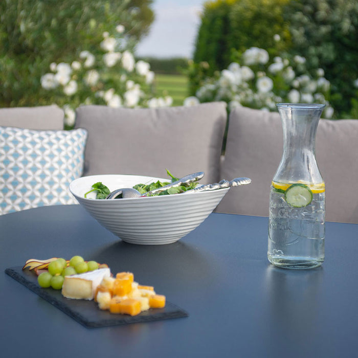 A close-up shot of the tempered glass table of the Pulse U Shape Corner Dining Set, elegantly set with snacks and drinks for outdoor dining.