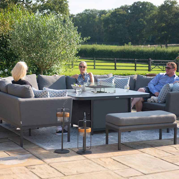 The Pulse U Shape Corner Dining Set with Fire Pit complemented by stylish lanterns, creating an ambient evening setting.